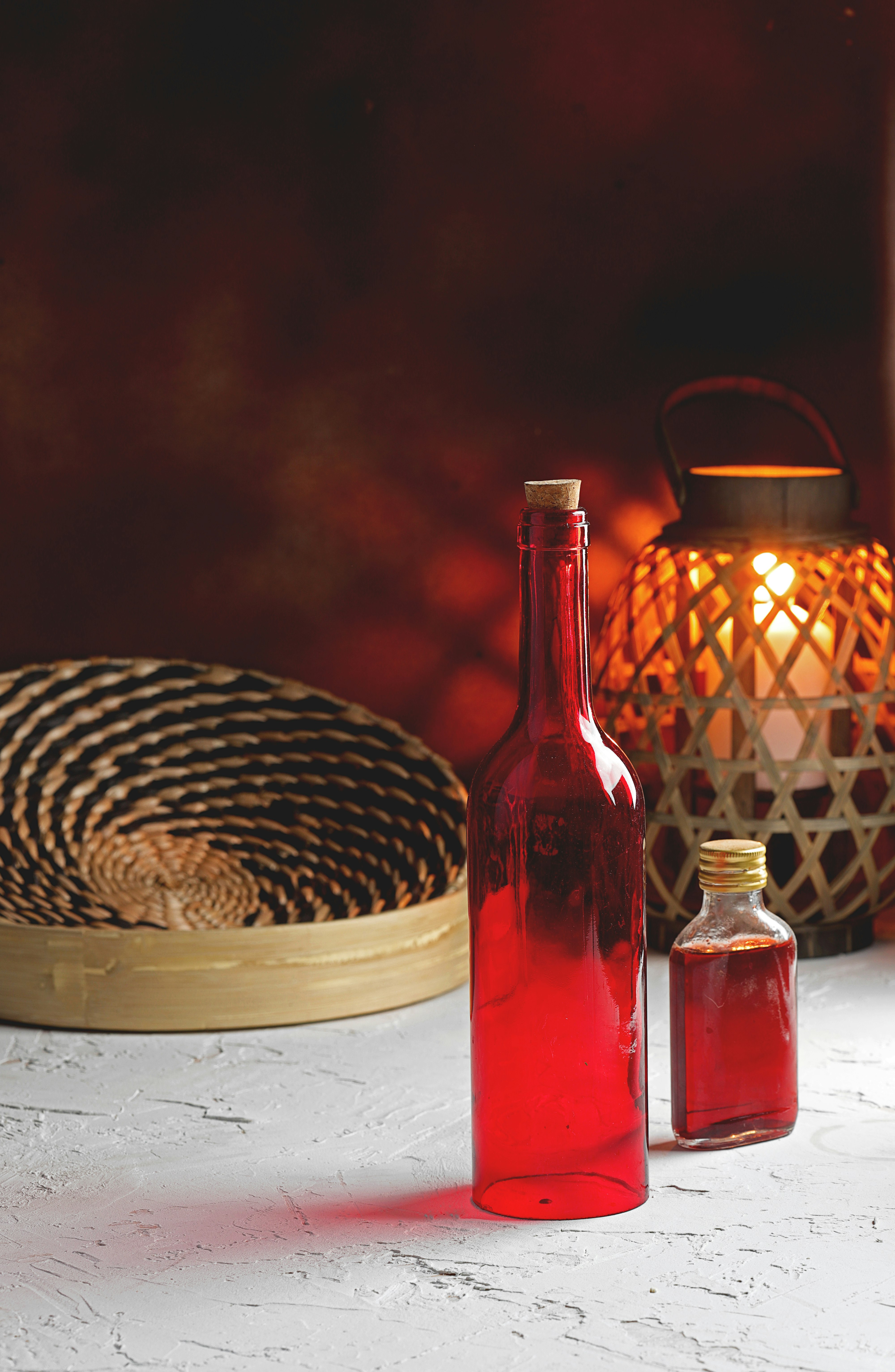 red glass bottle beside brown and black leopard print textile